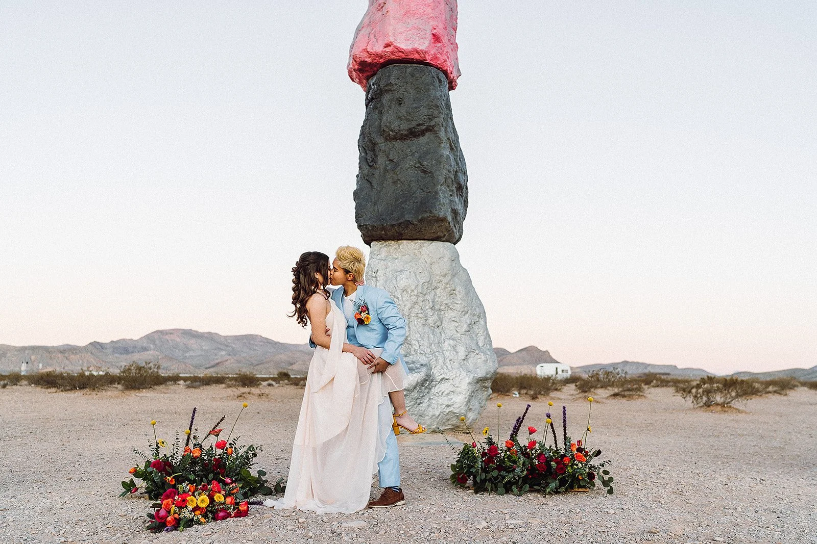 Couple kissing after eloping at sunrise at seven magic mountains.