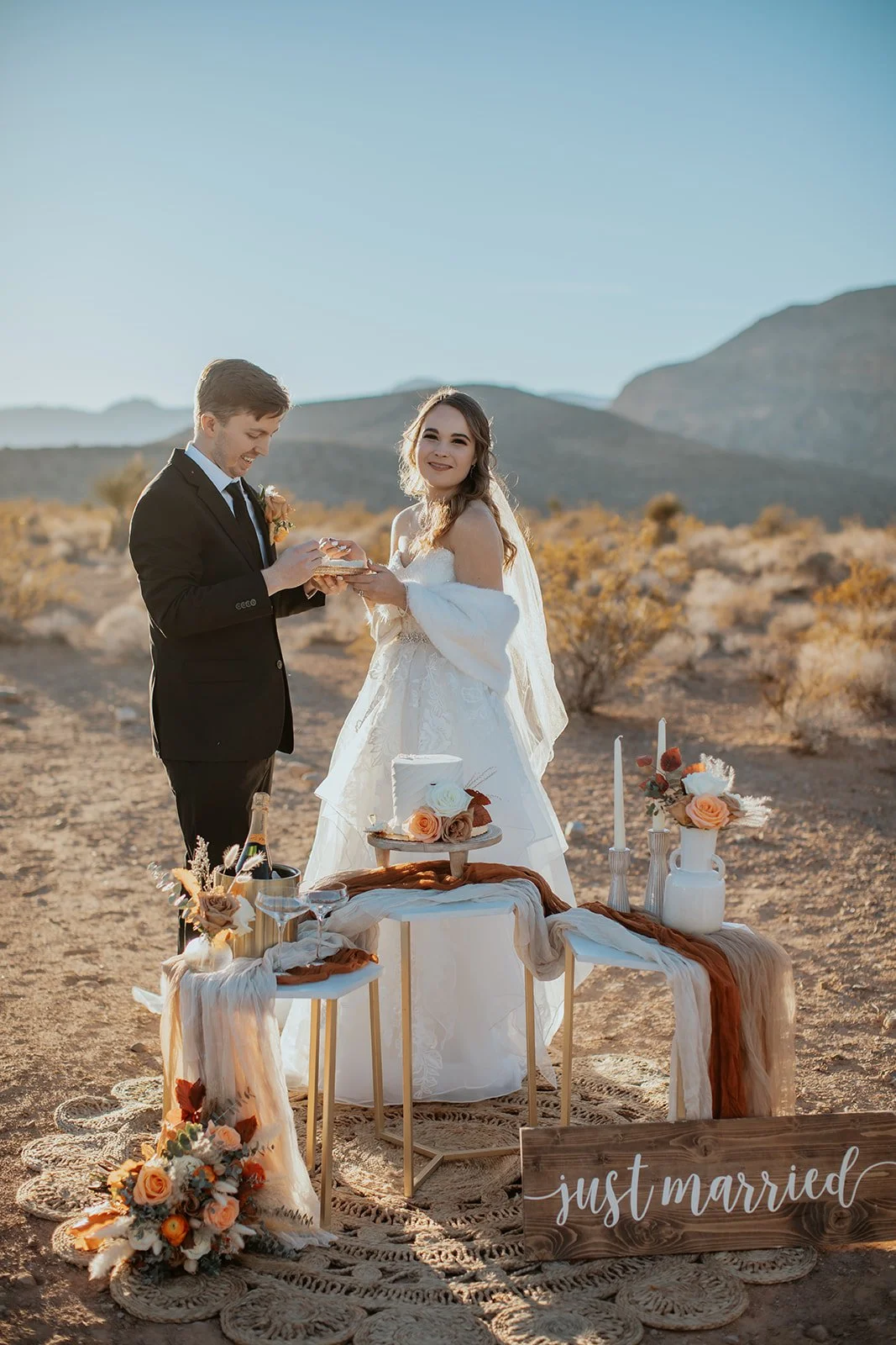 Couple eating cake and sipping champagne after eloping in the desert at Cactus Joe’s with Elopement Las Vegas.